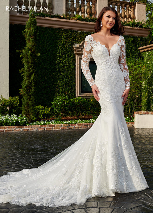 A young woman wear a beautiful mermaid style bridal gown in the color ivory nude.